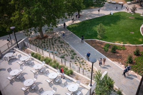 A view of the west pathway and outdoor seating area of the Carolyn and Kem Gardner Commons. The pathway shown leads to the A. Ray Olpin Union Building. 